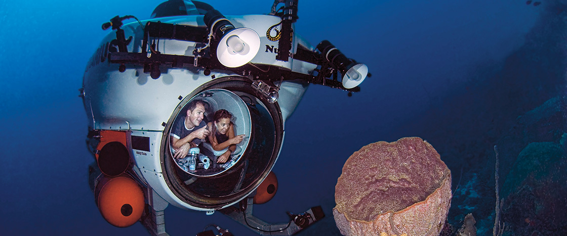 Photo of people in a submersible viewing the ocean